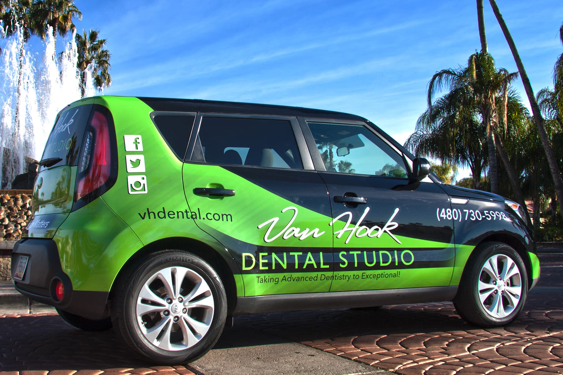 Kia Soul with a green and black vehicle wrap featuring Van Hook Dental